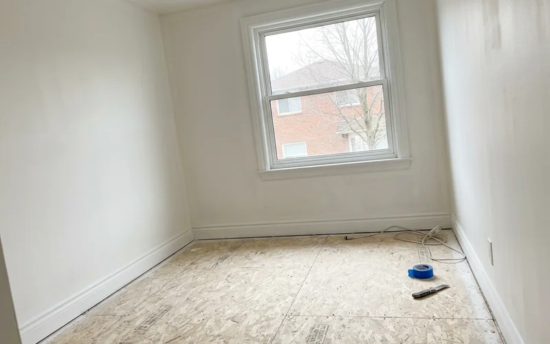 Empty bedroom with sealed subfloor ready for new flooring