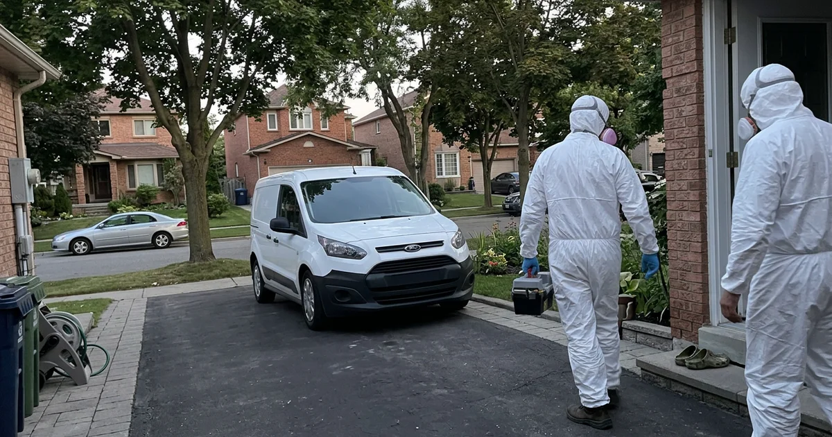 Two crew members entering a quiet home at dusk, unmarked van in the driveway