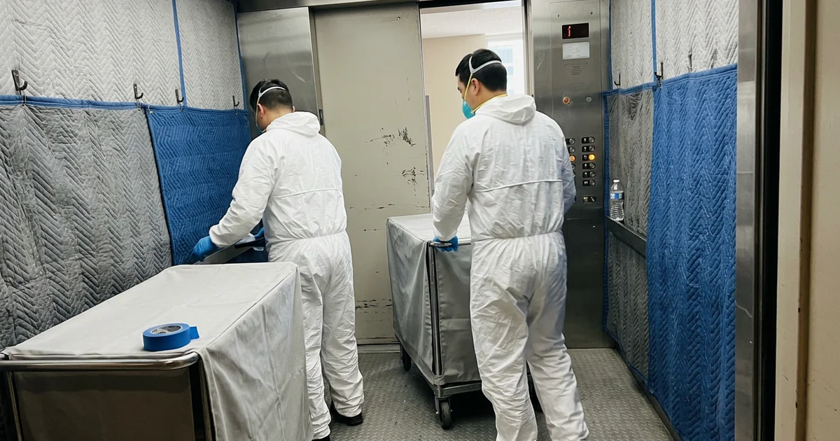 Crew with covered carts in a condo service elevator