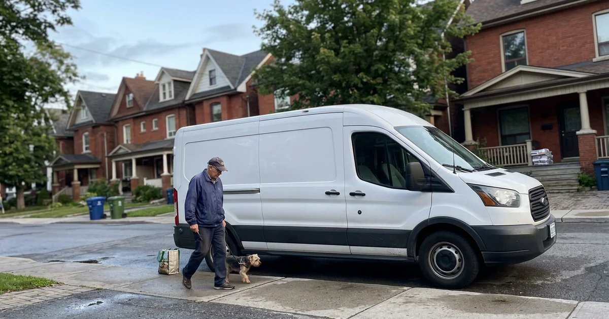 Unmarked white van parked discreetly on a quiet Toronto street at dawn