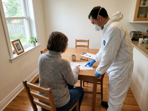 Crew lead and family member reviewing a sorting plan at the kitchen table