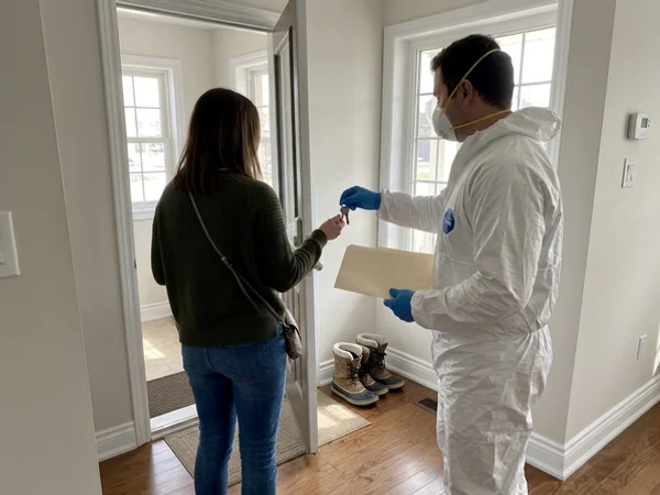 Crew lead handing keys and a folder to the realtor