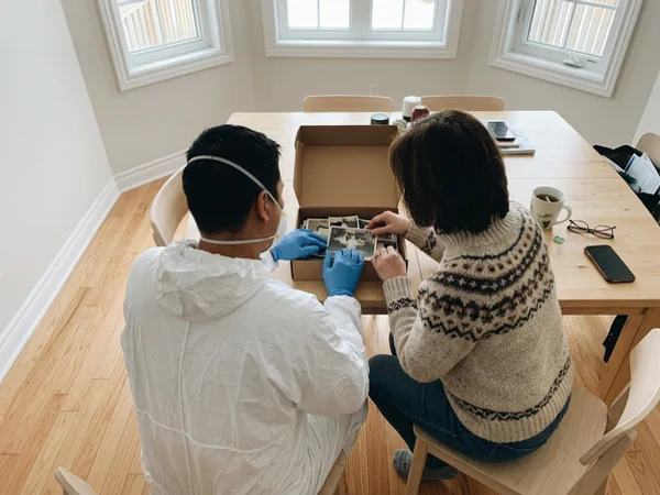 Crew member and family member reviewing a box of photos