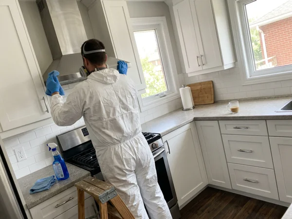 Crew member degreasing a range hood