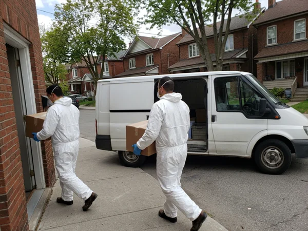 Crew carrying sealed boxes to an unmarked white van