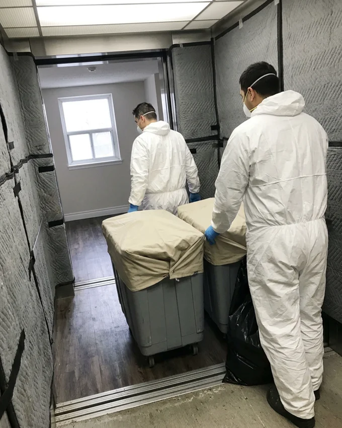 Crew with covered carts in a condo service elevator